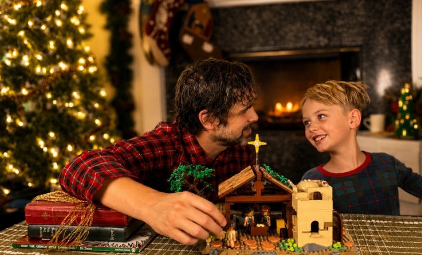 A dad and son building the Nativity set together